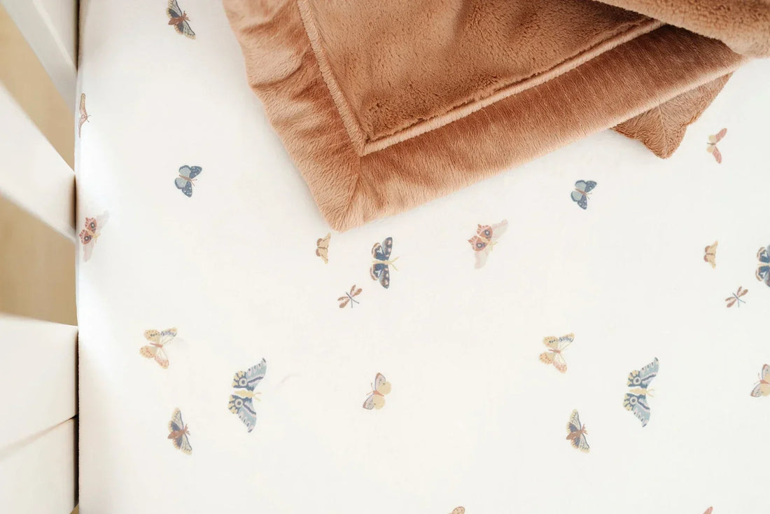A close-up of a buttery soft Lush blanket with in-house embroidery in warm tones, showing the texture and quiet detail of a personalized baby gift.