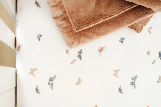 A close-up of a buttery soft Lush blanket with in-house embroidery in warm tones, showing the texture and quiet detail of a personalized baby gift.