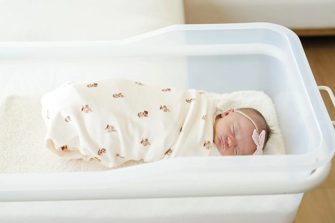 A close-up of a buttery soft Lush blanket with in-house embroidery in warm tones, showing the texture and quiet detail of a personalized baby gift.