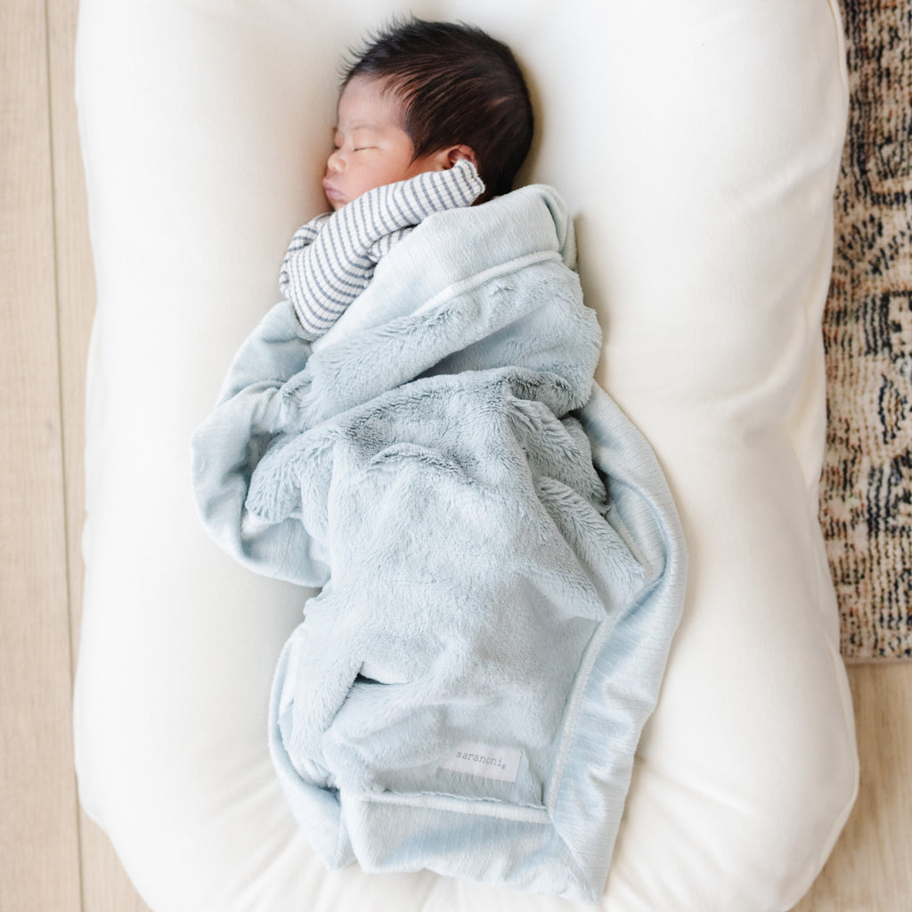Baby snuggled in a light blue blanket
