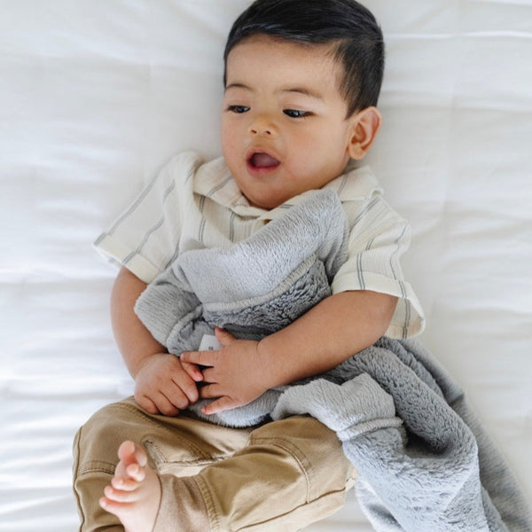 A baby boy holds a Gray Colored Lush Saranoni Blanket. The soft blanket is a small blanket and a baby blanket or toddler blanket.