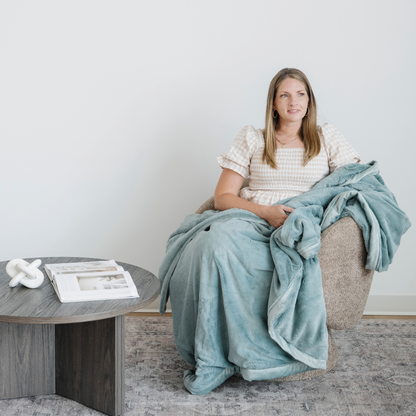 Woman sitting in chair with a Lush XL blanket.