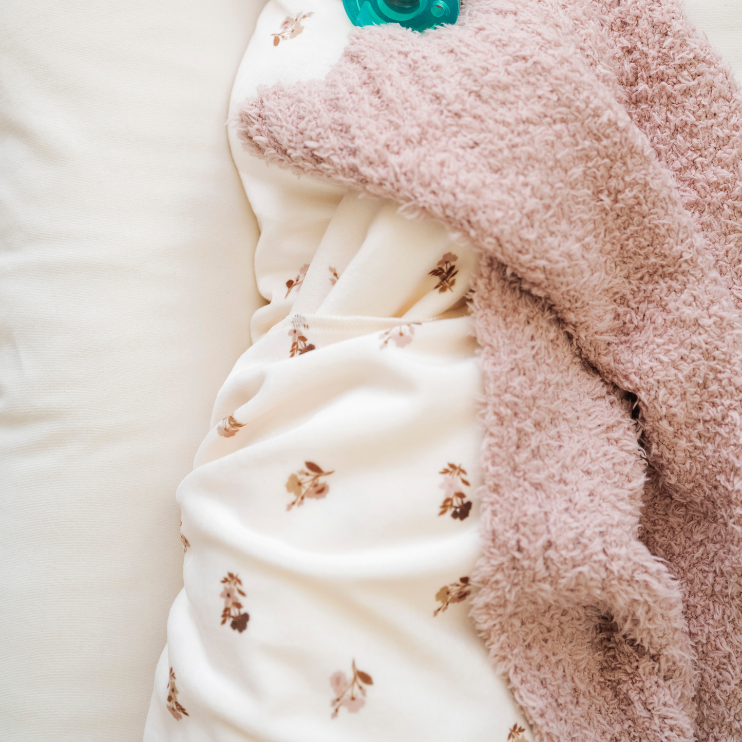 A floral minky stretch luxe swaddle and a pink baby blanket from Saranoni.