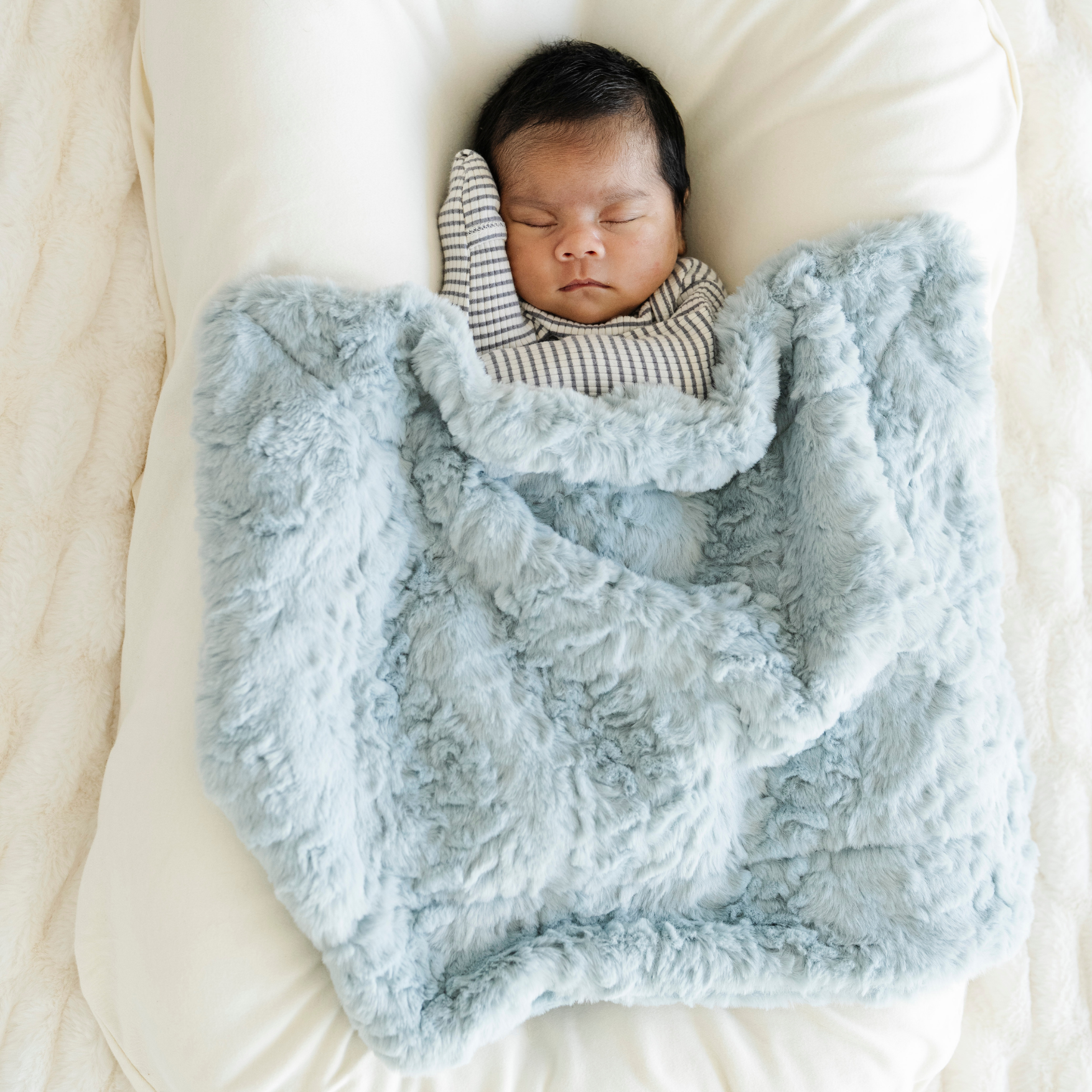 Baby boy snuggled with Heather Blue Dream Mini Baby Blanket.