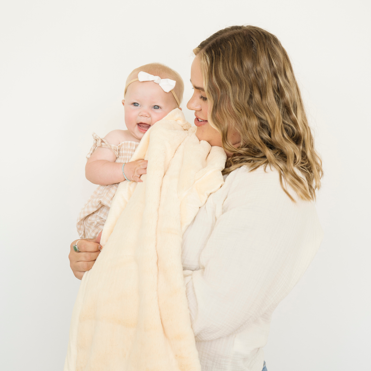 Mom holding baby girl snuggled with Lush receiving soft baby blanket in Chiffon yellow. 