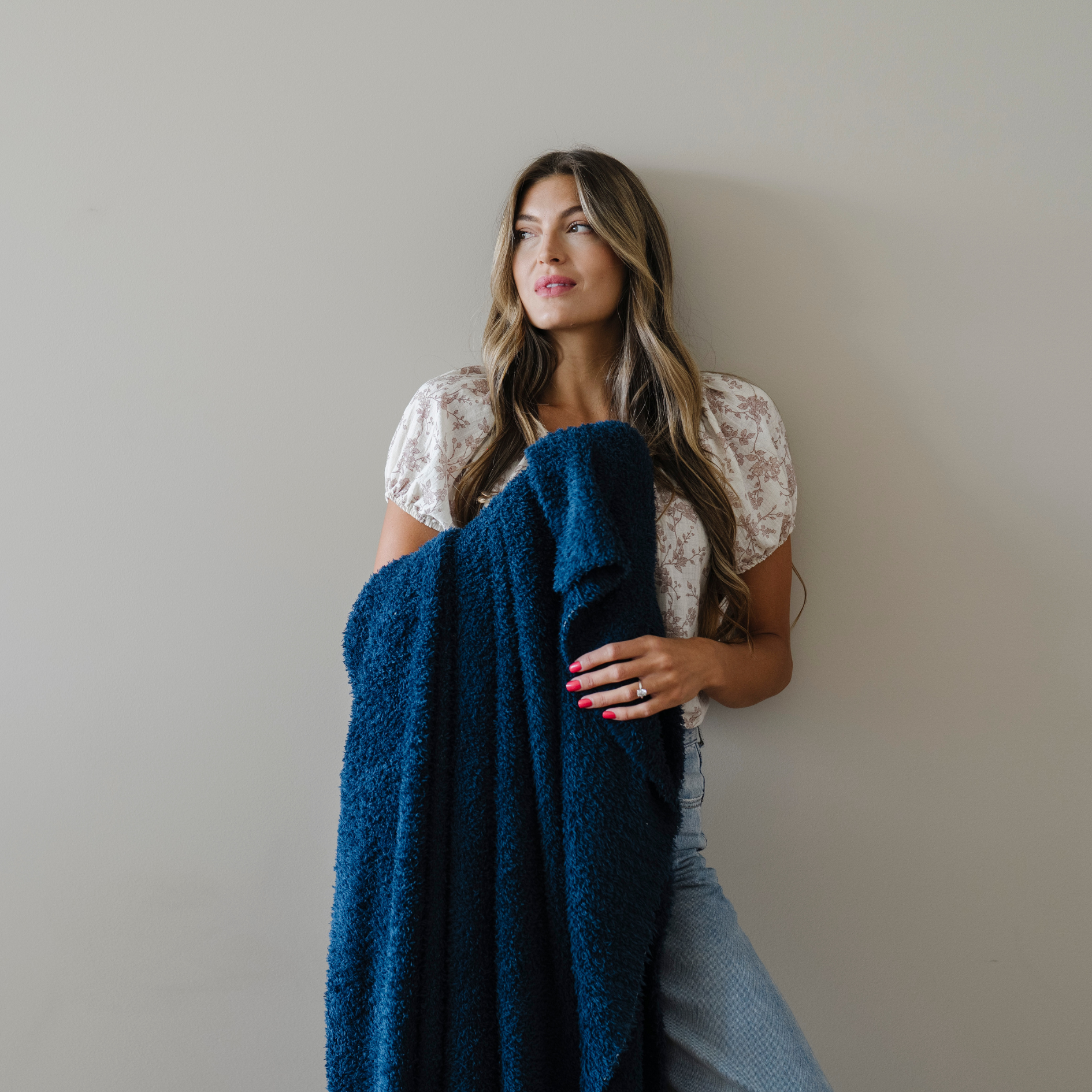 Woman snuggled with nautical blue bamboni extra large blanket.