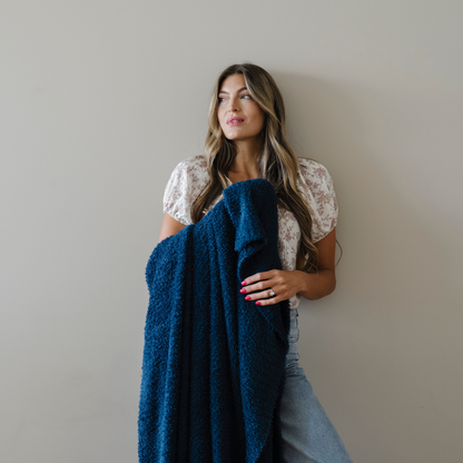 Woman snuggled with nautical blue bamboni extra large blanket.
