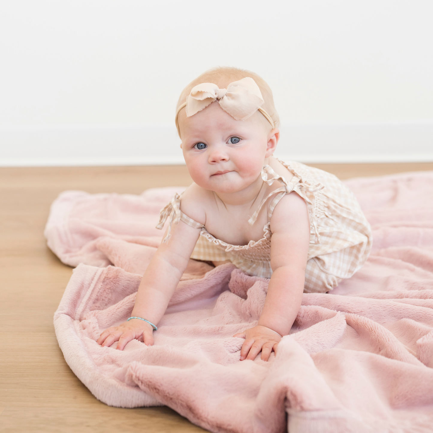 Baby girl crawling on Saranoni Lush Receiving soft baby blanket in Ballet Slipper pink color. 
