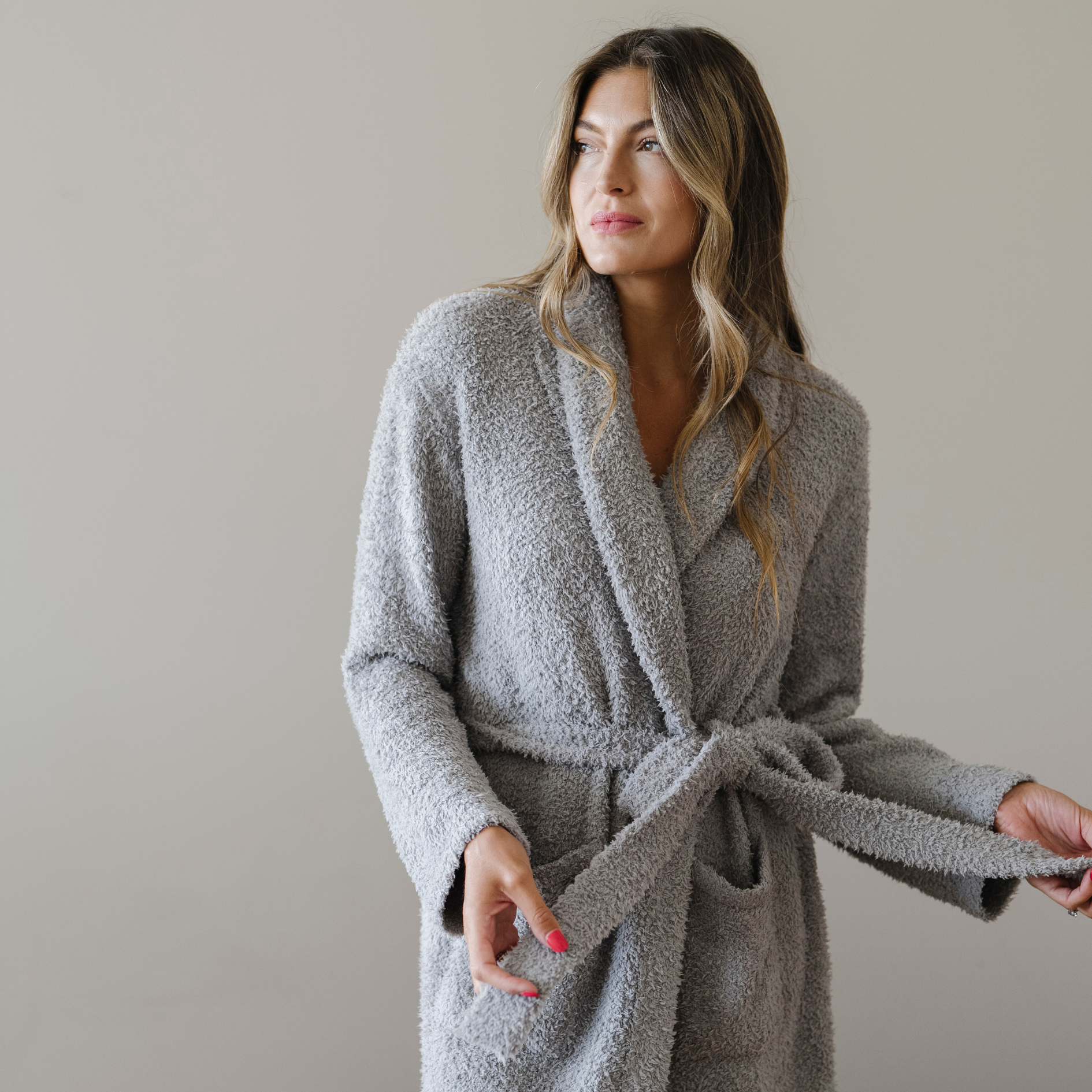 Woman wearing a cozy luxury gray robe. 