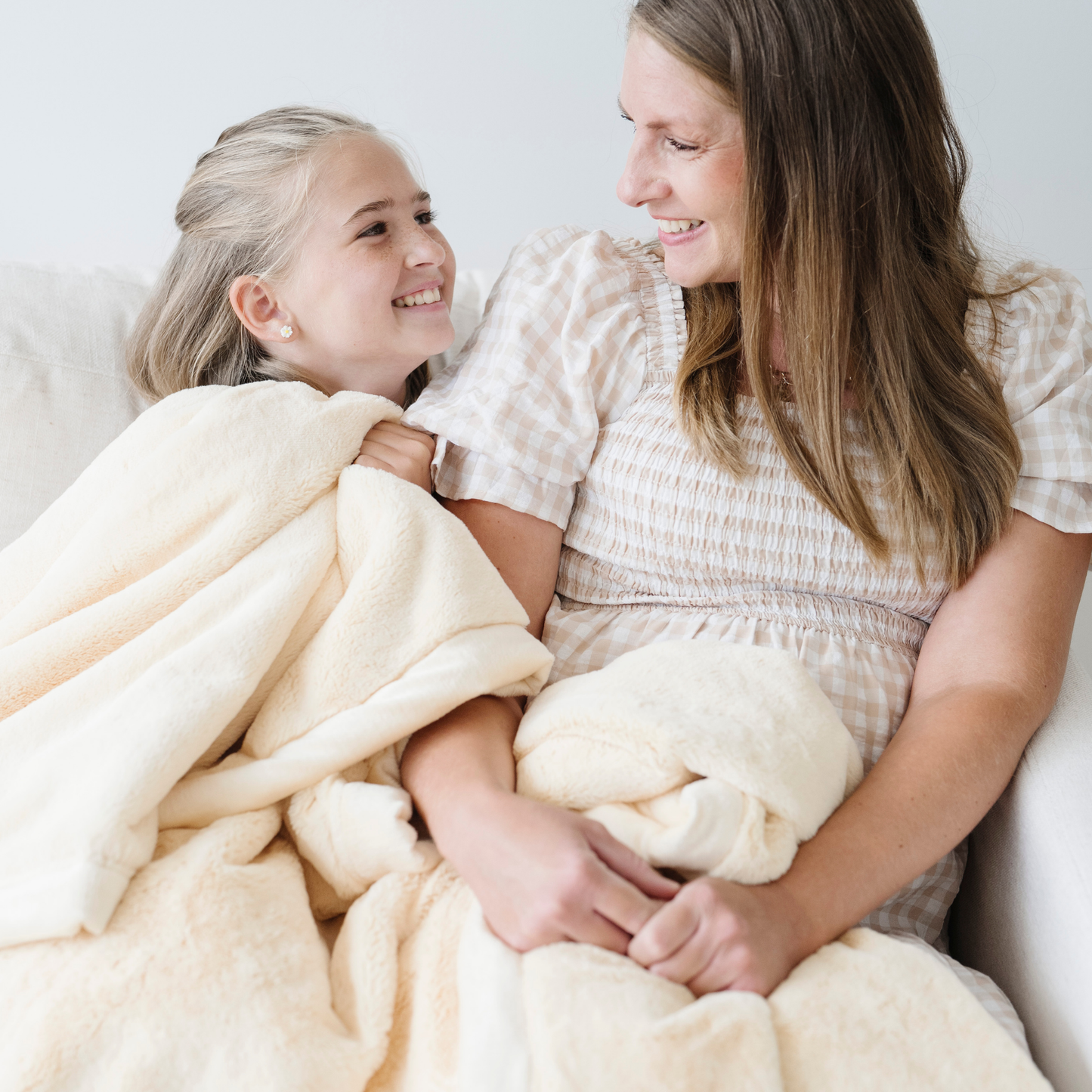 Mom and daughter snuggle in chiffon yellow lush xl blanket. 