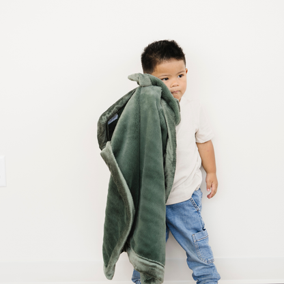 Toddler Boy holding Hunter Green Lush receiving blanket. 