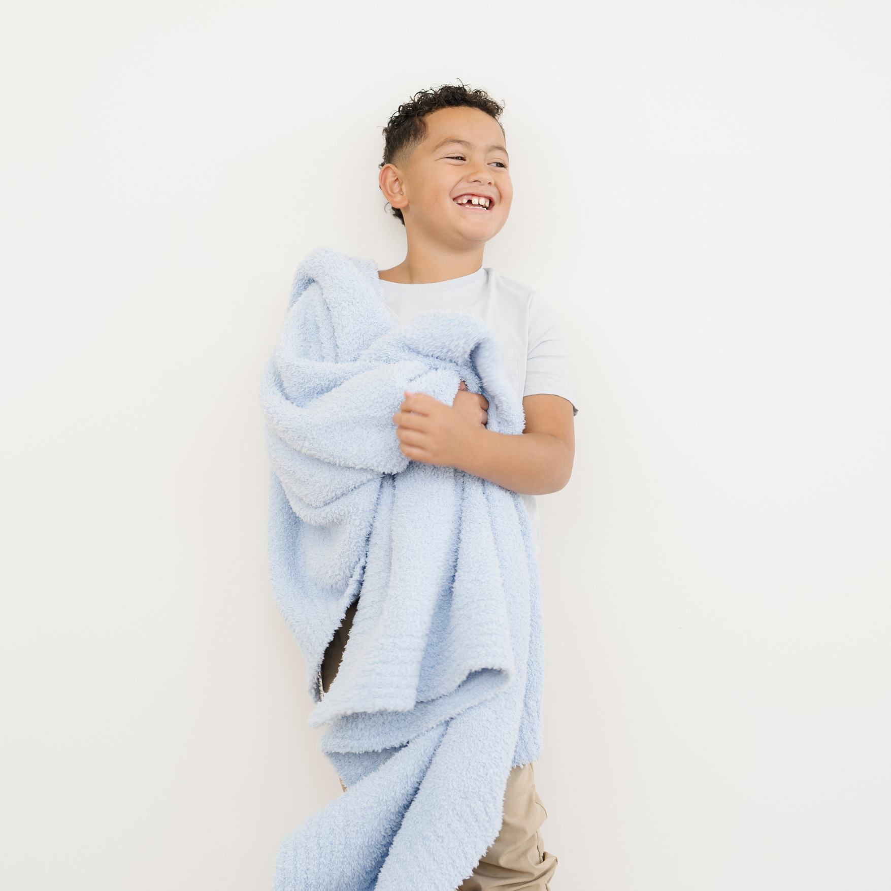 Boy snuggled with Light Blue Bamboni® Toddler Blanket.