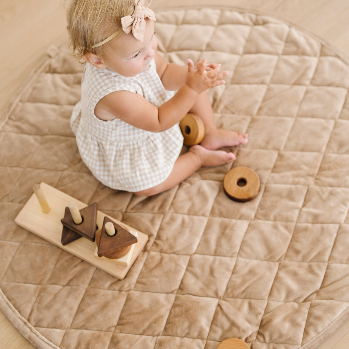 Baby girl plays on minky play mat. 