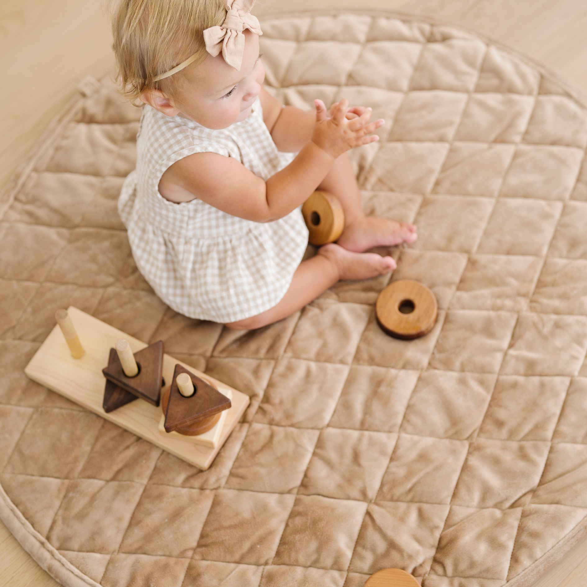 Baby girl plays on minky play mat. 