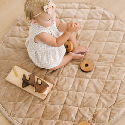 Baby girl plays on minky play mat. 