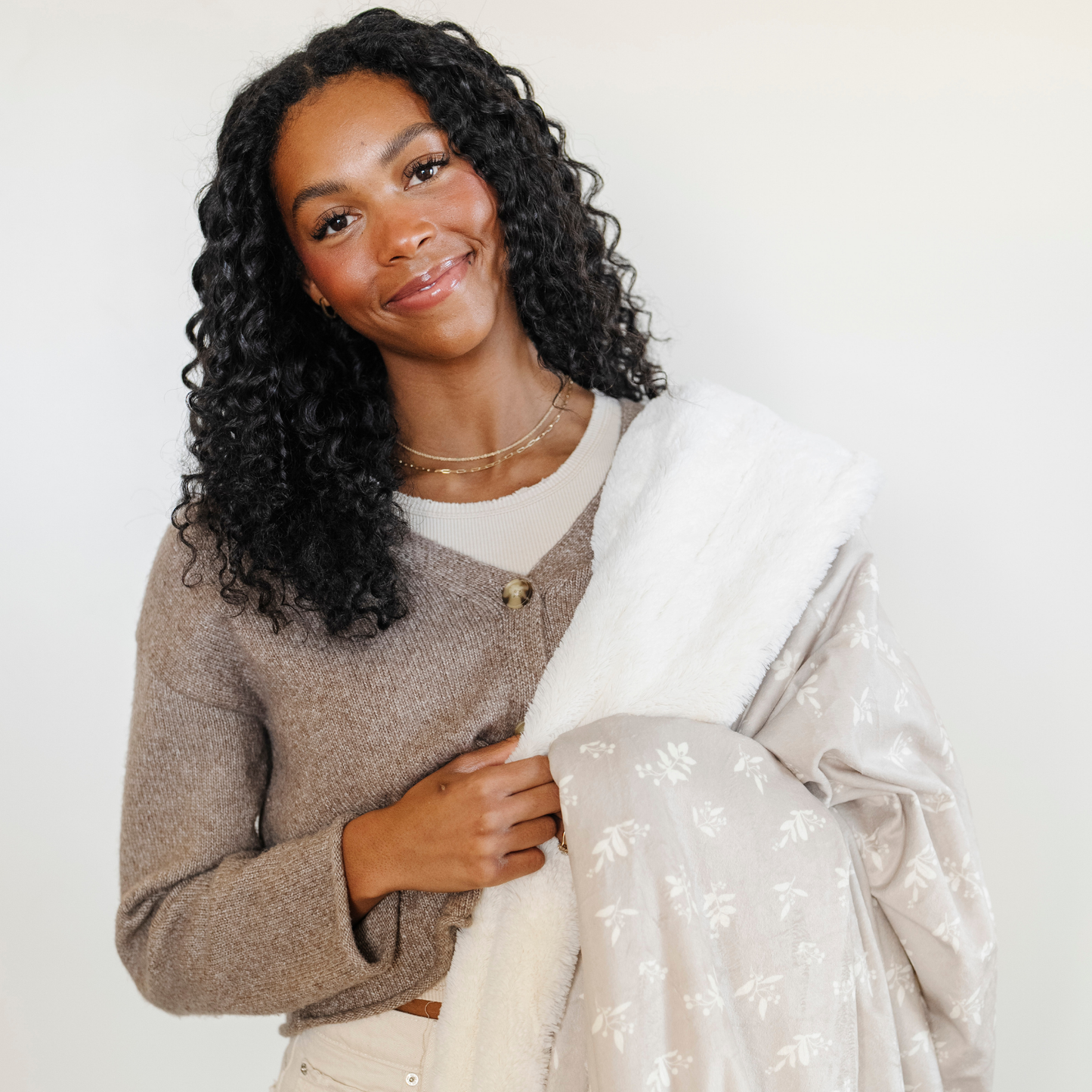A woman holds a soft Saranoni minky/lush blanket. This extra-large throw blanket features Saranoni’s signature cream lush fabric on one side and ultra-soft floral printed minky on the other. Designed for ultimate relaxation, this high-quality, plush blanket is perfect for snuggling, movie nights, and adding a touch of luxury to any home. This soft blanket is a luxury blanket and a Saranoni blanket. The cozy blanket is a perfect comfort gift and is also beautiful for home decor. 