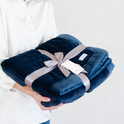 A Navy Lush XL Saranoni blanket, designed for oversized comfort and featuring a buttery soft, plush texture. This luxurious Saranoni blanket is perfect for cozy evenings, reading, or home decor. The Saranoni blanket adds warmth, style, and unmatched softness, making it an ideal gift or essential for ultimate relaxation.