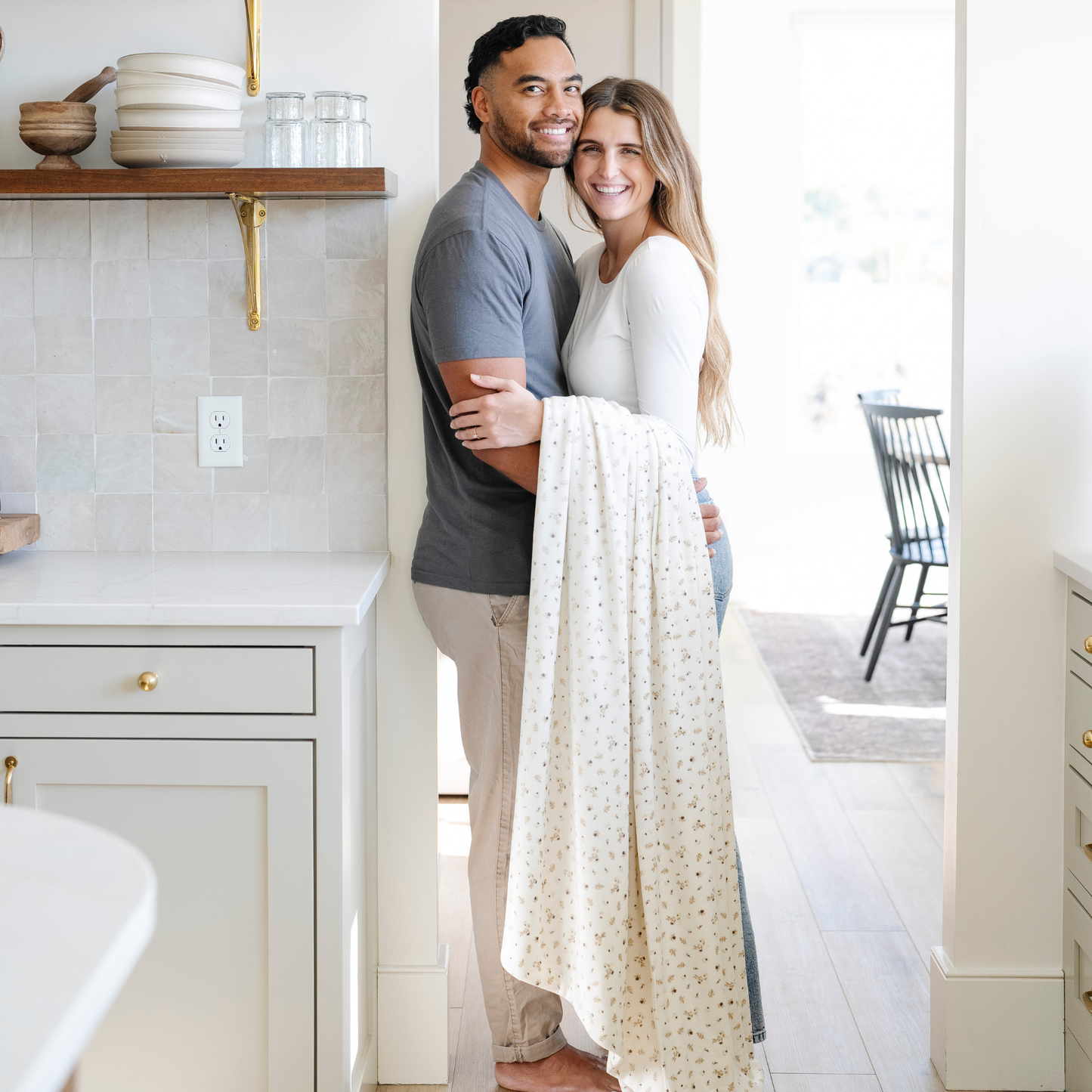A husband and wife with a floral minky stretch blanket. This soft blanket is a Saranoni blanket and is very durable and stretchy. This cozy blanket is perfect for gifting, lounging, and on the go. 