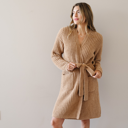 Woman stands wearing the Allspice Saranoni Waffle Knit robe. 