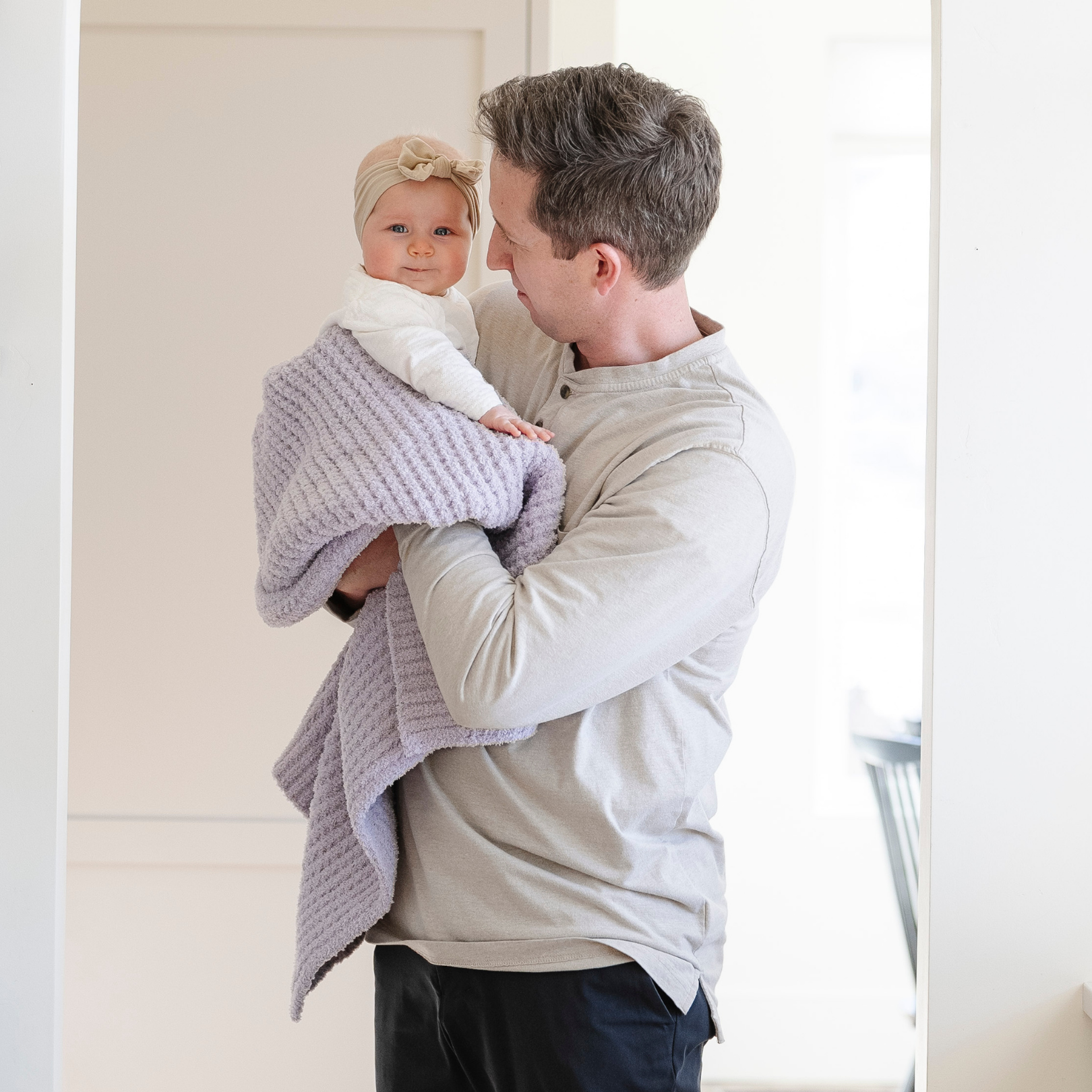 A father holds his little girl in a buttery-soft Saranoni blanket, featuring a breathable, plush waffle texture in a soothing light purple hue. This luxury receiving blanket is the best baby blanket as a  newborn blanket, infant blanket, baby blanket, or toddler blanket—perfect as a cozy blanket for snuggles or a must-have infant blanket. Designed for softness and comfort, this plush baby blanket makes an ideal baby gift or gift for new moms. Enjoy this luxury blanket!