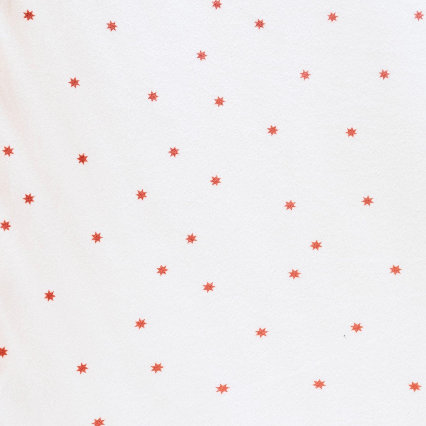 Close-up of Minky Stretch Luxe fabric in a delicate star pattern. Made from 94% polyester and 6% spandex, this ultra-soft, stretchy fabric is perfect for baby essentials like swaddles, changing pad covers, and crib sheets.
