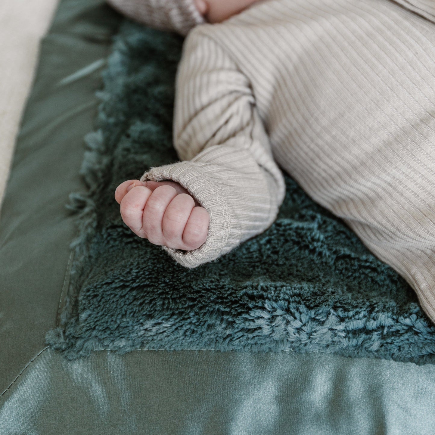 Cozy mini blanket with a plush texture and a delicate satin border, offering warmth and a touch of luxury in a compact size.