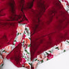 Red blanket with floral satin trim.