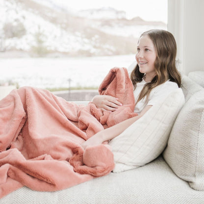 A girl holds a Luxury Toddler Clay Colored Lush Saranoni Blanket. The soft blanket is a toddler blanket or baby blanket.