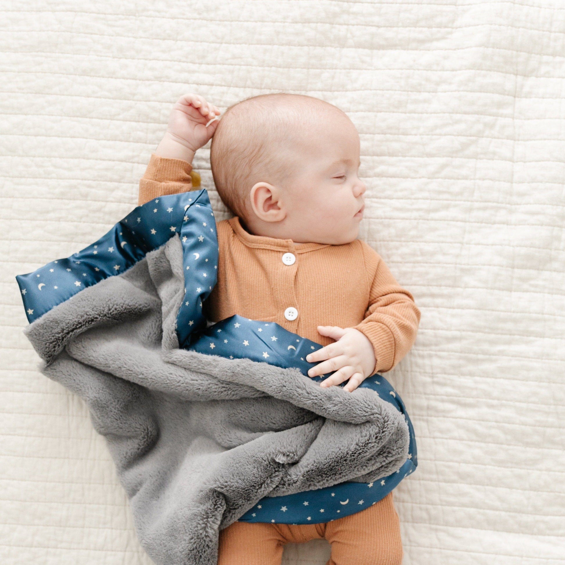 Snuggly mini blanket featuring a velvety-soft fabric and a satin border, offering a cozy wrap with an elegant, silky touch