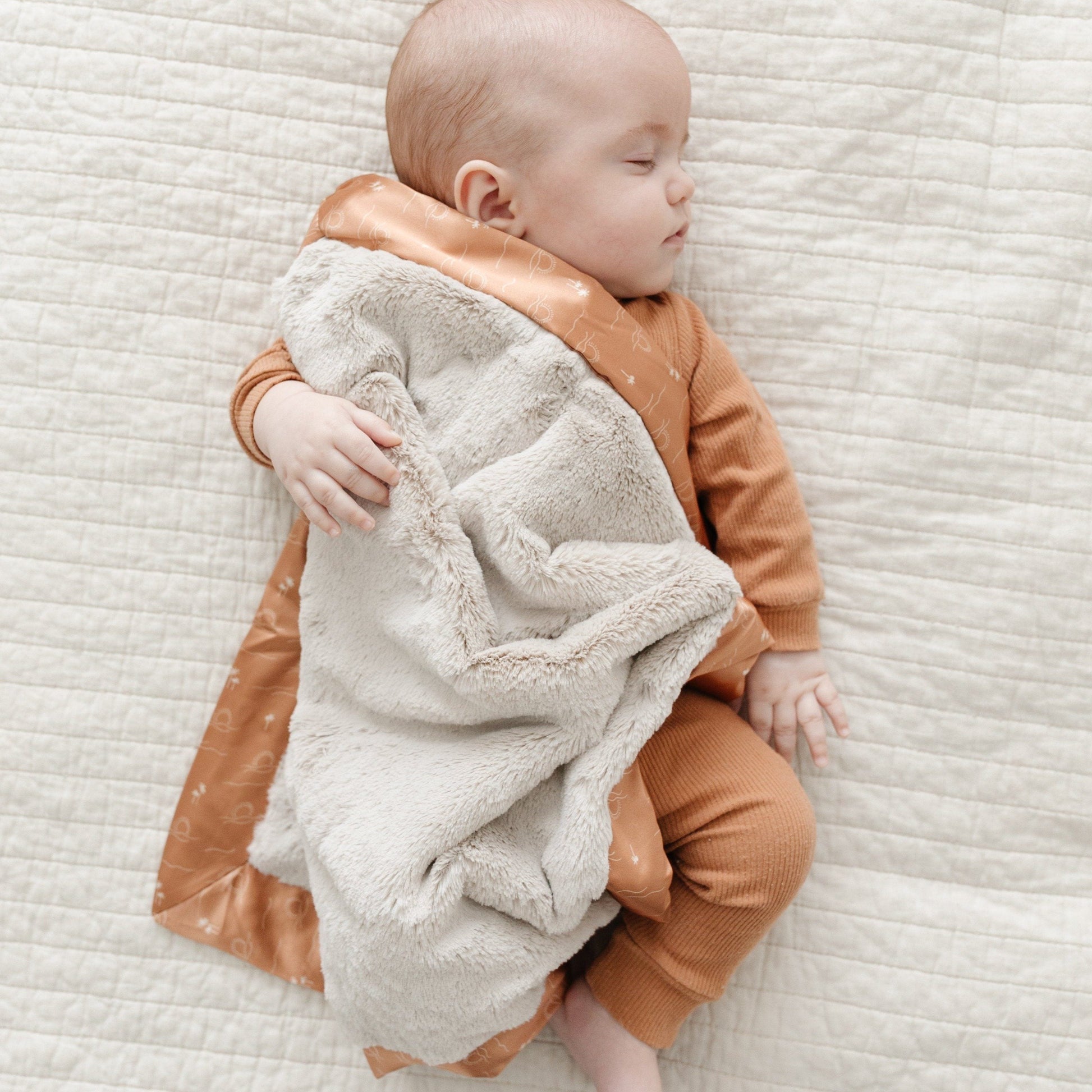 Compact mini blanket with a rich, velvety surface and a satin border, perfect for wrapping in warmth and elegance.