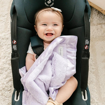 Baby with a light purple mini blanket with a satin border, offering a cozy, warm feel with an elegant, silky edge for added sophistication.