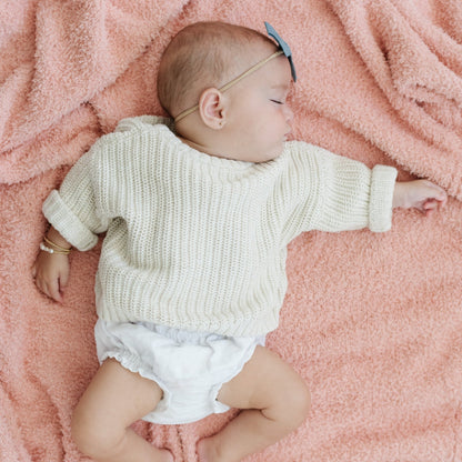 Adorable baby girl falling asleep on Peach BAMBONI® RECEIVING BLANKETS - Saranoni