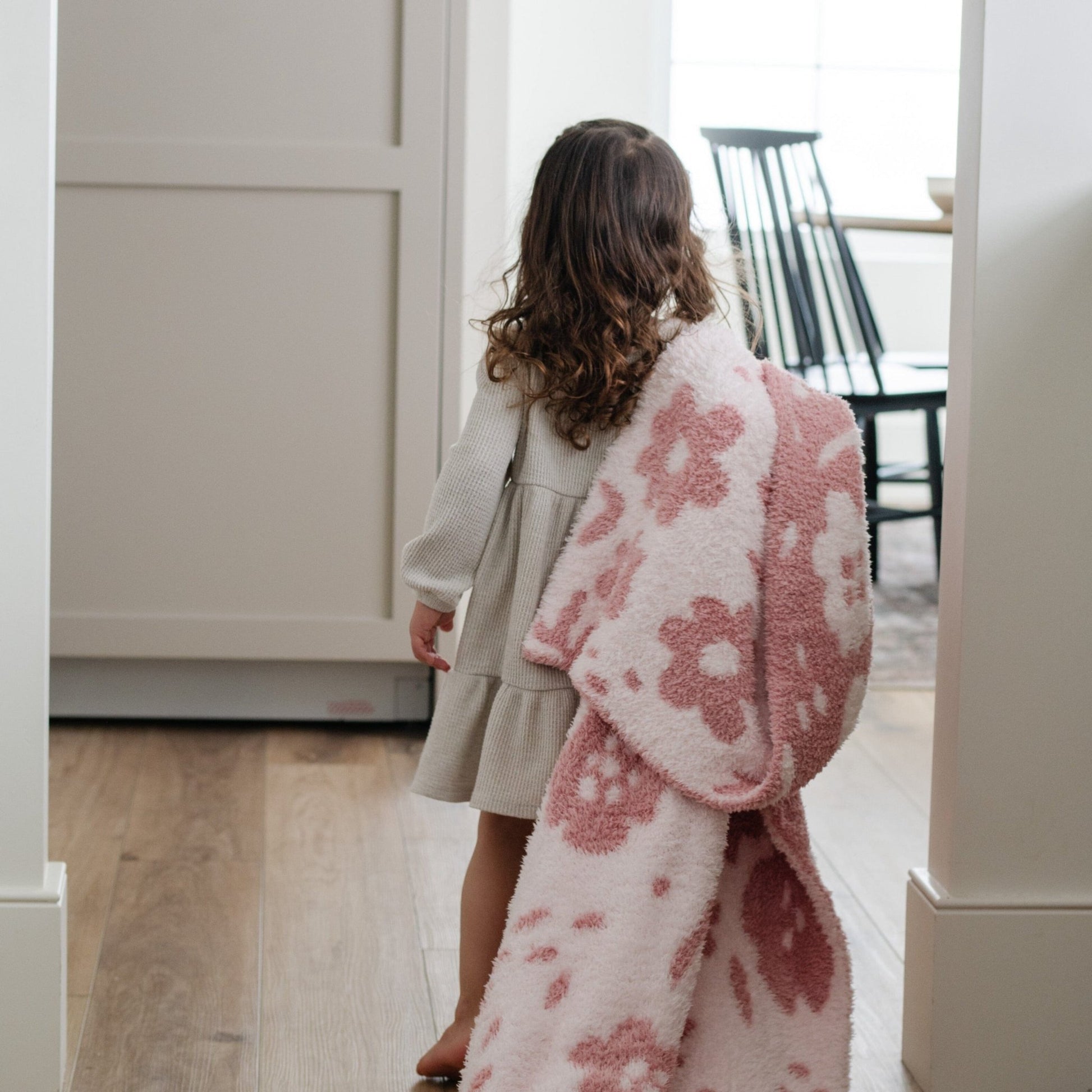 A little girl holds a double-layer Bamboni® blanket. The plush, breathable blanket features a two-tone light pink and pink floral design, offering ultimate softness and warmth. Made from Saranoni’s signature stretchy, cloud-like Bamboni® fabric, this luxury kids blanket provides comfort for naps and on-the-go snuggles. The soft blanket is a toddler blanket and Saranoni blanket. 