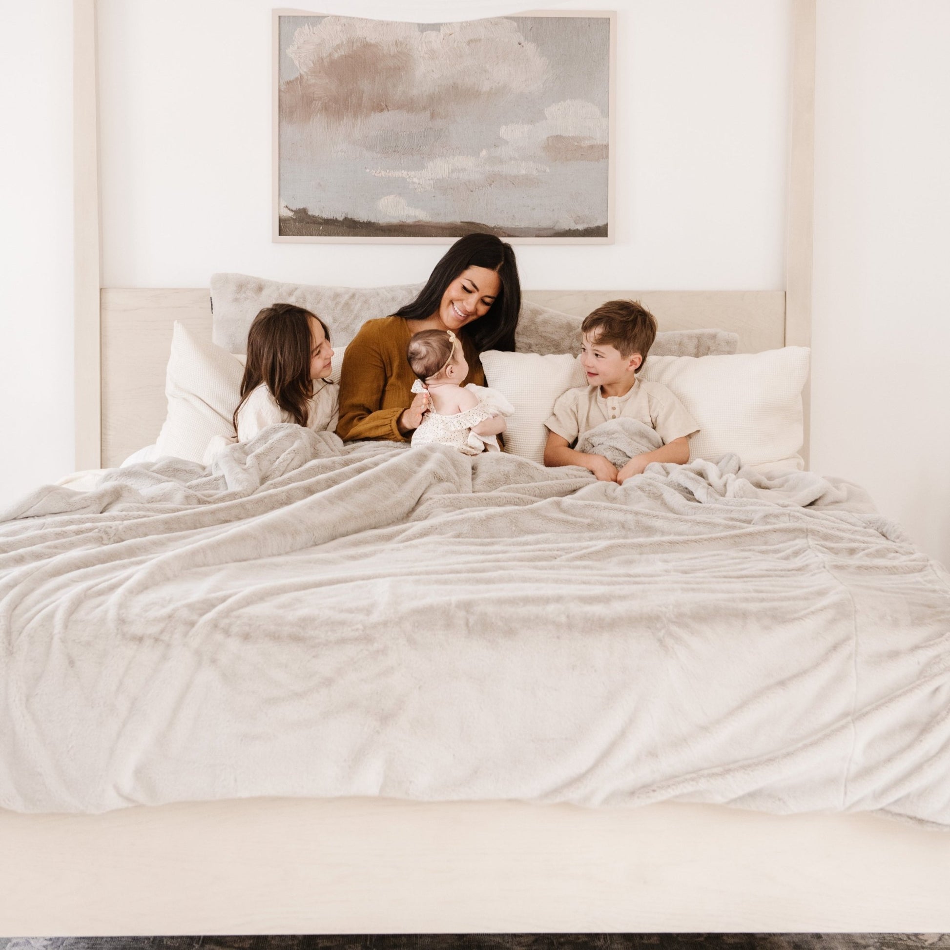 Family cuddled under a Saranoni blanket, showcasing its incredible softness.