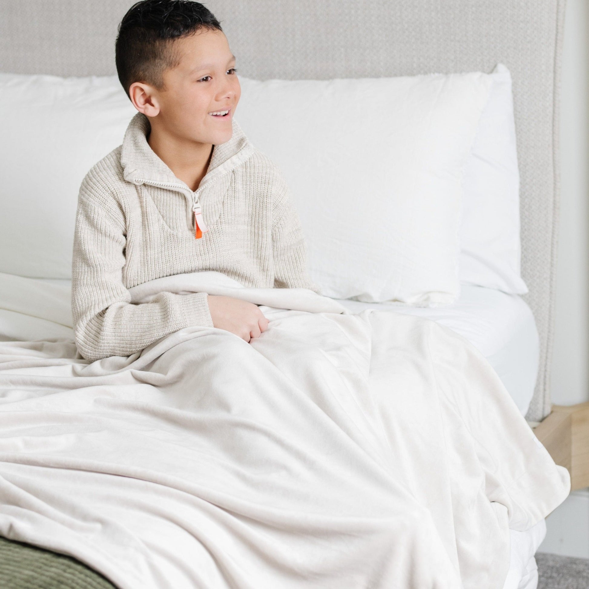 Boy smiling in bed with feather MINKY STRETCH RECEIVING BLANKETS - Saranoni