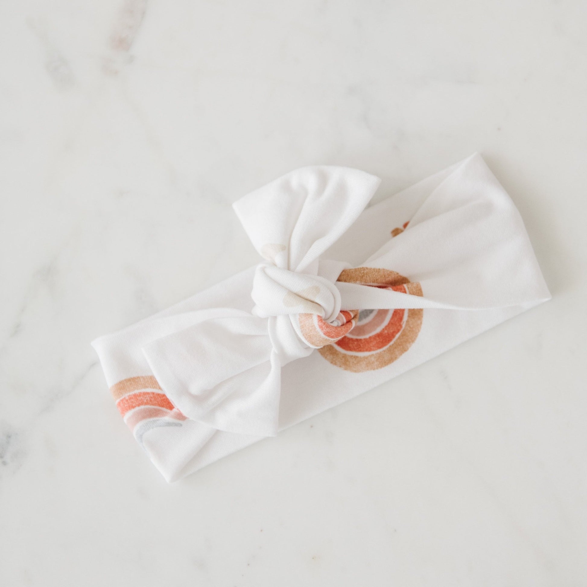 Adorable baby girl bow headband in rainbow print, soft material! Saranoni